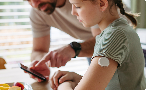 Girl with father monitoring her diabetes